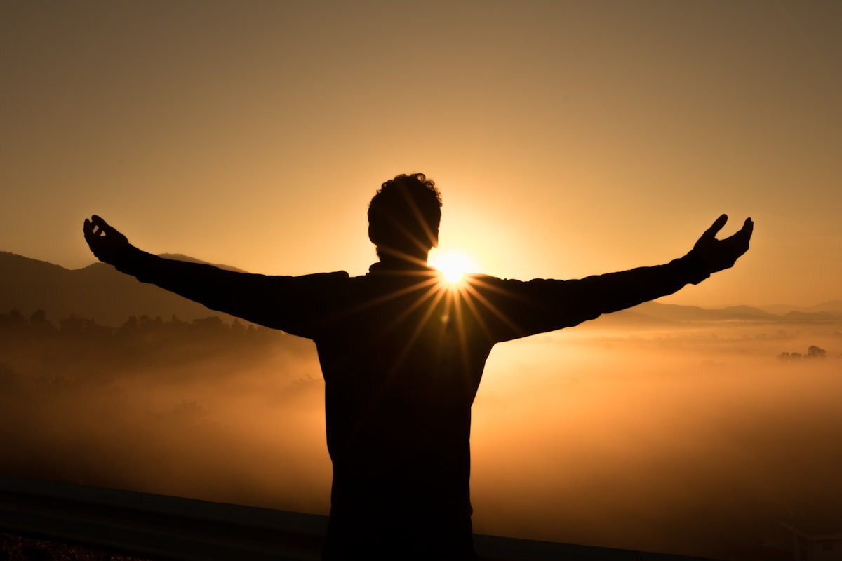 A person standing at a mountain summit, symbolising the mental challenge of reaching the highest levels of physics olympiad achievement
