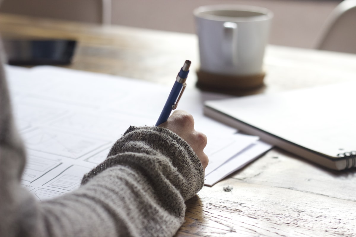 A student working through problems in a notebook, representing the accessible entry point that the BPhO provides