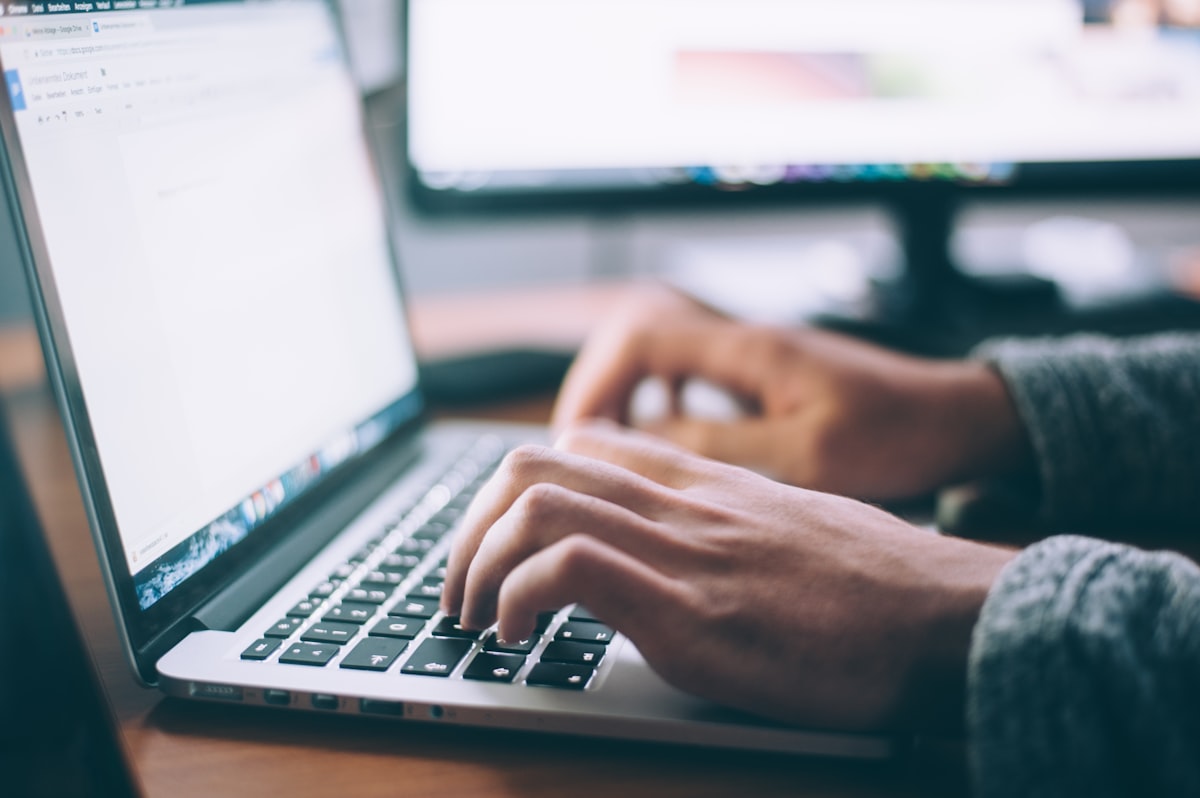 A person working at a laptop representing the online registration process for schools