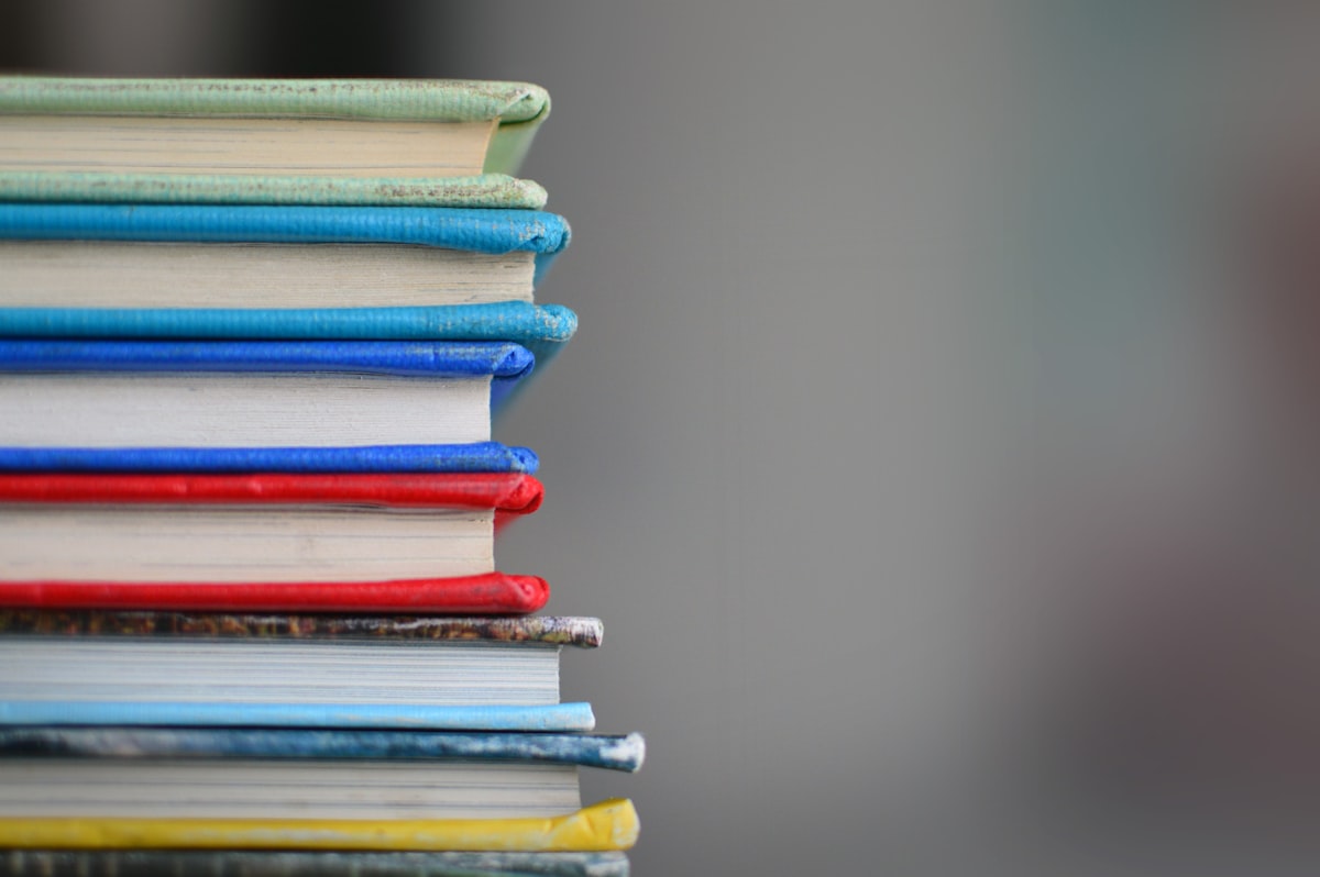 Stack of books representing the extensive mathematical and physical reference library needed for BPhO