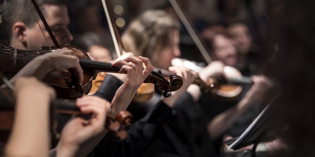 A full orchestra performing in a grand concert hall